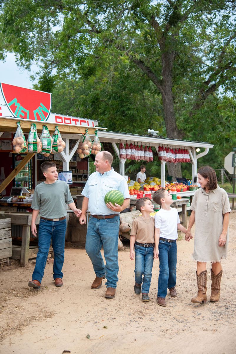 mom and daughter walking through tomato crop