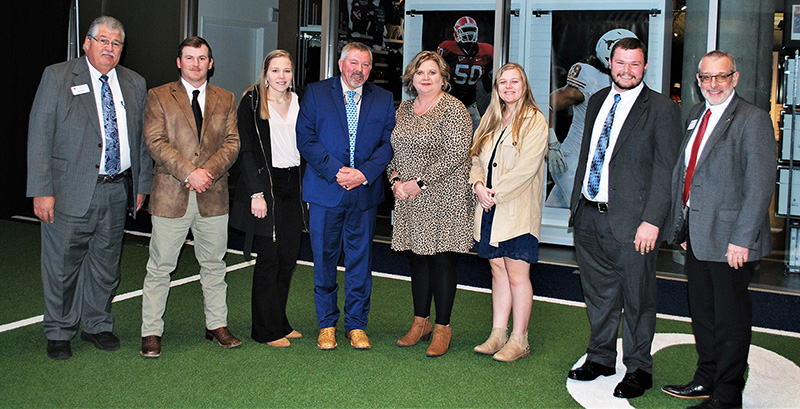 From left, UGA Extension Assistant Dean Mark McCann joins Justin Pate, Christian Pate, Scotty Raines, Melanie Raines, Celie Raines, Guy Hancock and CAES Dean Nick Place at a celebration announcing Scotty Raines' selection as 2022 Georgia Farmer of the Year during the annual meeting of the Georgia Agribusiness Council. (Photo by University of Georgia)